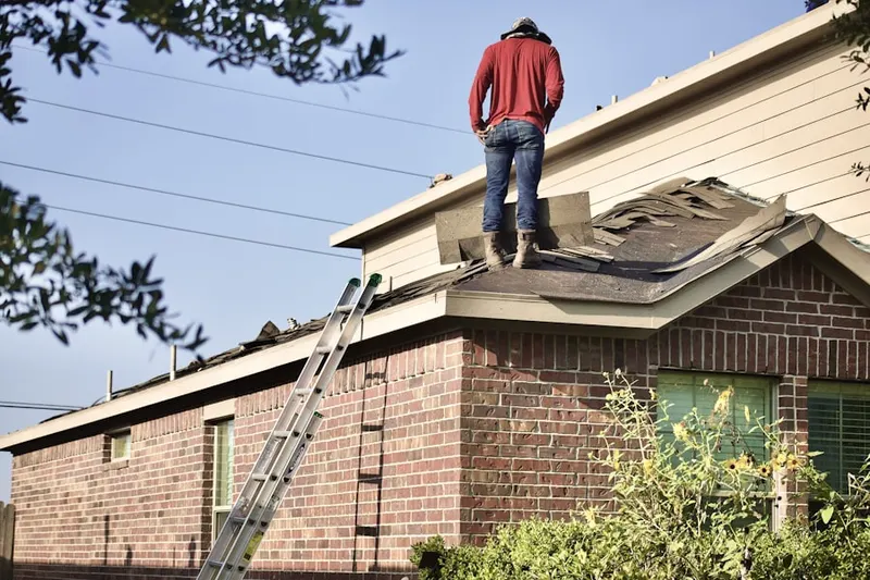 Professional roofer working on a residential roof in Jovita